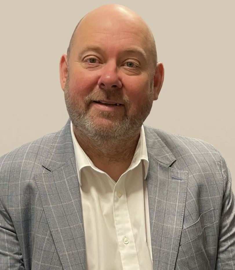 A man with a gray beard and gray suit jacket